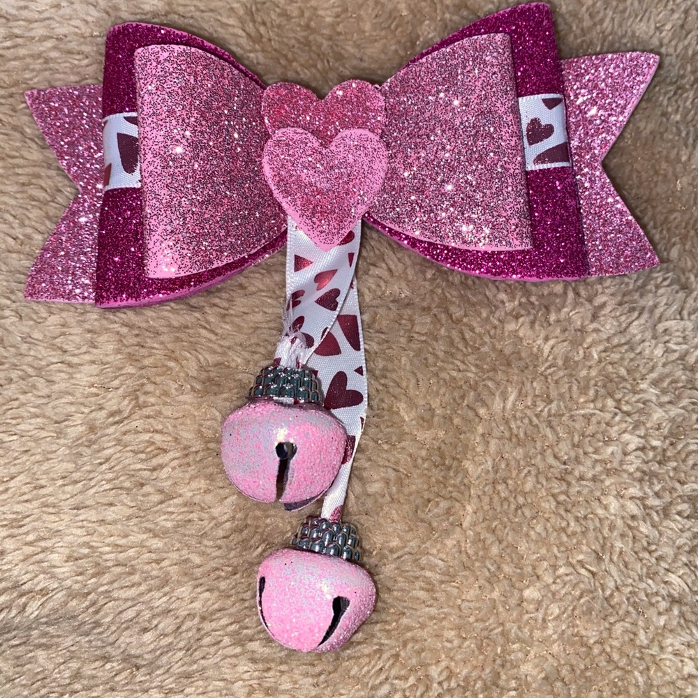 Pink hearted bow with bell.